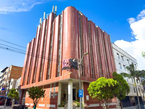 a large red building on a city street at Hotel Macedonia Plaza Itagui in Medellín