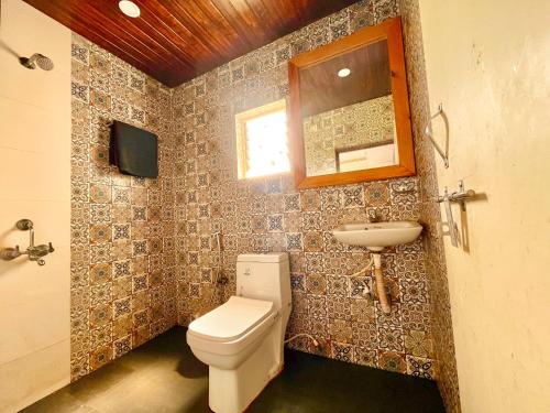 a bathroom with a toilet and a sink at The Four Season Hotel & Cottage, Goa in Candolim