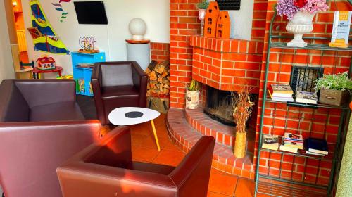 a living room with a brick fireplace and a chair at Best Western Spreewald in Lübbenau