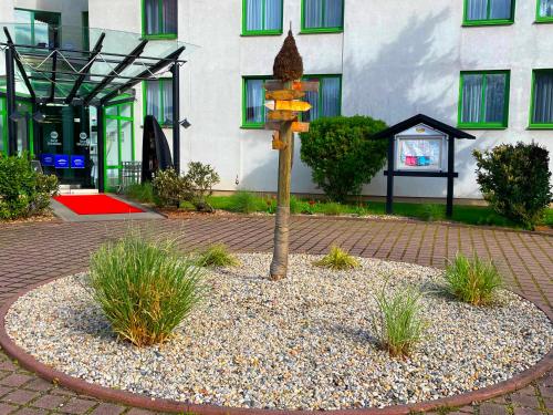a tree in a courtyard in front of a building at Best Western Spreewald in Lübbenau