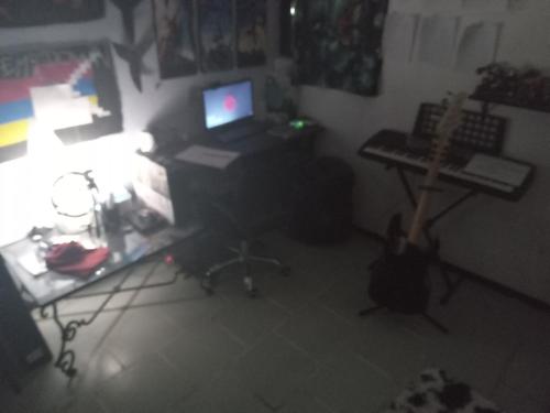 Cette chambre comprend un bureau avec un ordinateur portable et une guitare. dans l'établissement Hostal puebla, à Lomas de Angelopolis