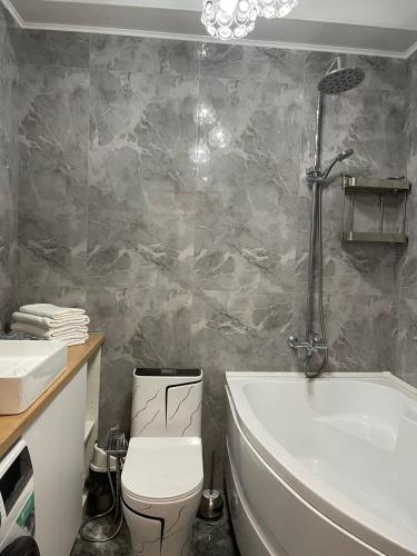 ein Badezimmer mit einem WC, einer Badewanne und einem Waschbecken in der Unterkunft Райский уголок in Almaty