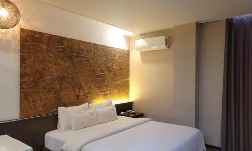 Jinhae Pasta Hotel في تشانغوون: غرفة فندق فيها سرير و لوحة على الحائط
