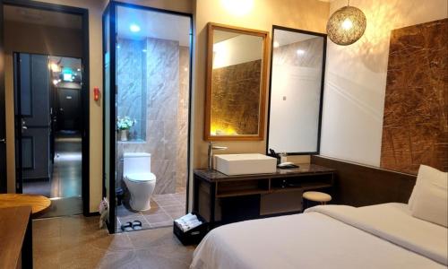 a bathroom with a bed and a sink and a toilet at Jinhae Pasta Hotel in Changwon