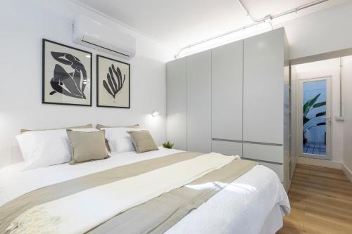 Un dormitorio blanco con una cama grande y una ventana en Loft 2D2B con Terraza en el Corazon de Santiago, en Santiago