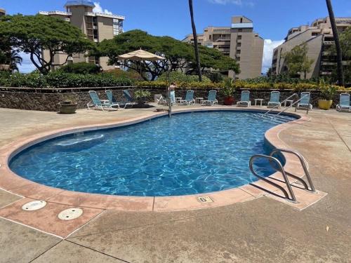 una piscina con sillas en un hotel en Modern Kahana getaway, en Kahana