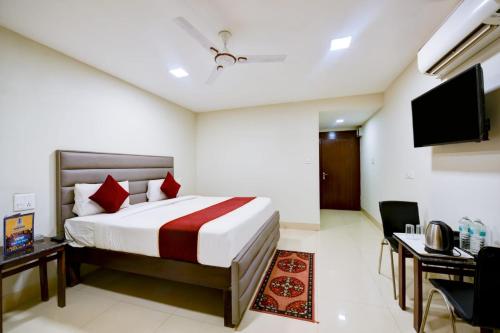 a bedroom with a bed and a desk and a television at Chauhan Hospitality IGI Airport New Delhi Mahipalpur in New Delhi