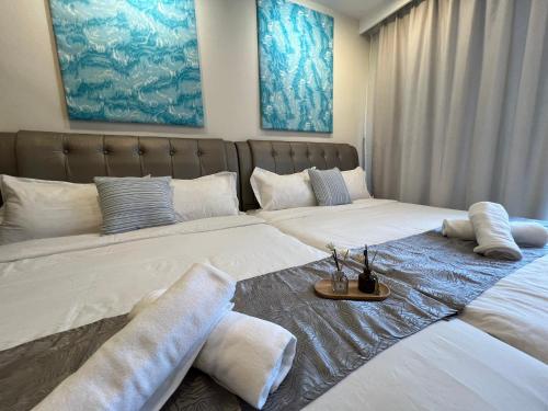 Duas camas com almofadas num quarto em VitaminSEA3 Seaview 6PAX Studio Netflix A-8-13A em Kuantan