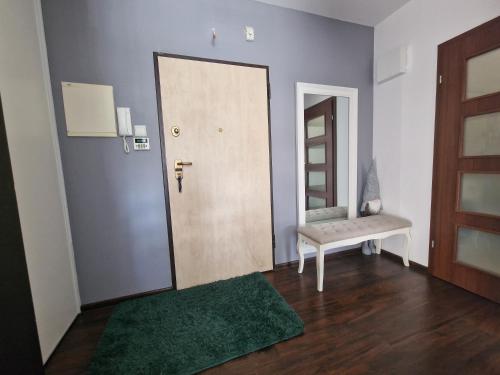 a room with a door and a bench and a mirror at Apartament Kocham Gdańsk in Gdańsk