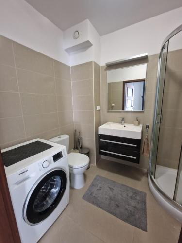 a bathroom with a washing machine and a toilet at Apartament Kocham Gdańsk in Gdańsk