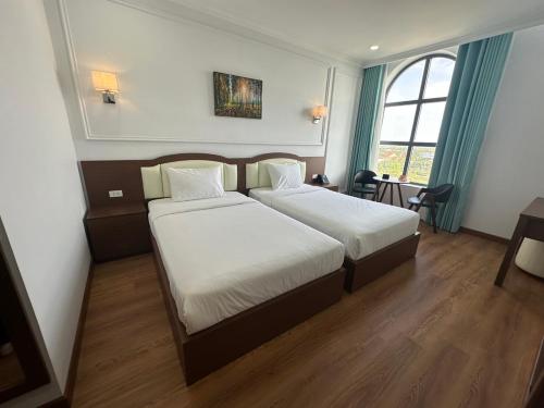 een hotelkamer met 2 bedden en een raam bij Ngoc Thu Palace in Soc Trang