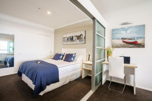 a hotel room with a bed and a desk and a desk at Princes Wharf - Luxury in Auckland