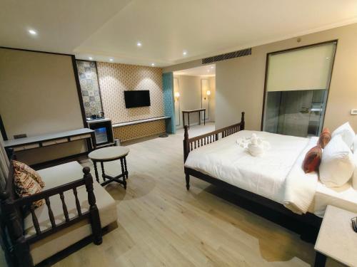 a hotel room with a bed and a flat screen tv at Rajwadu The Village in Jamnagar