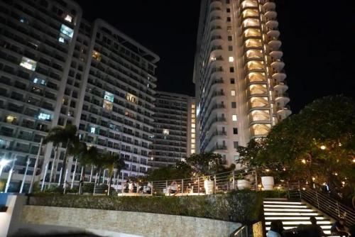 マニラにあるAzure Urban Residences Beach and Resort by Vookleyの夜の都市の高層ビル2棟