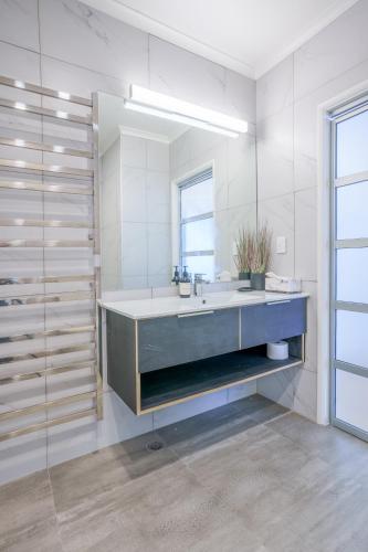 a bathroom with a sink and a mirror at Princes Wharf - Luxury in Auckland