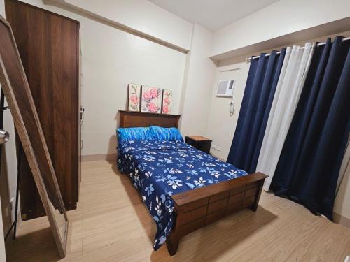 - une chambre avec un lit doté de draps bleus et de rideaux bleus dans l'établissement Shanata Suntrust, à Manille