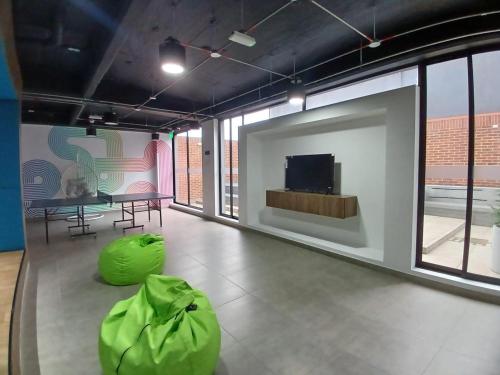 Habitación con mesa y TV en la pared. en Moderno apartamento 211 en Bogotá