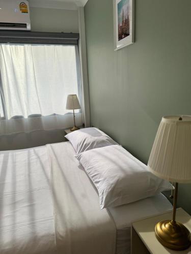a bedroom with a white bed and a window at O'Shea's Sukhumvit Bangkok in Khlong Toei