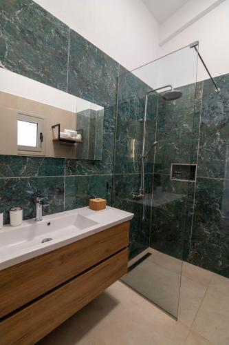 a bathroom with a sink and a glass shower at Anassa Villas in Vráchos