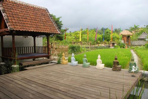 un groupe de statues en caoutchouc assises sur une terrasse en bois dans l'établissement Anandinii River Lodge, à Sidemen