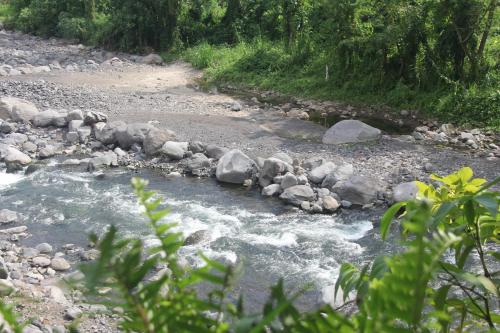 a river with rocks on the side of it at Anandinii River Lodge by AGATA in Sidemen