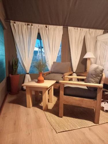 ein Wohnzimmer mit einem Sofa und einem Tisch in der Unterkunft MAISHA SWEETWATERS CAMP in Ol Pejeta Conservancy
