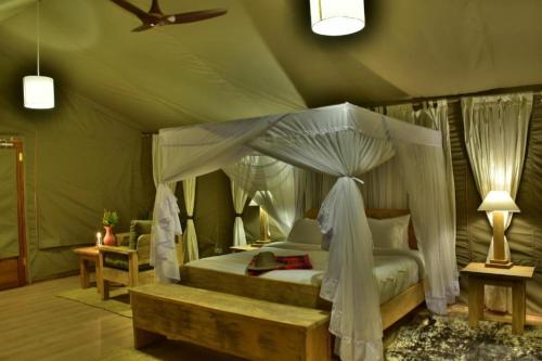 Ol Pejeta Conservancy的住宿－MAISHA SWEETWATERS CAMP，一间帐篷内带天蓬床的卧室