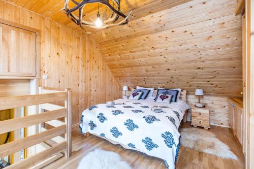 a bedroom with a bed in a wooden cabin at Chatka Gaździnek in Czarna Góra