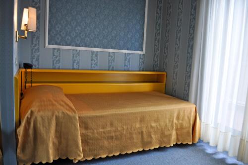 a bedroom with a bed with a yellow bedspread at Hotel Garda in Milan