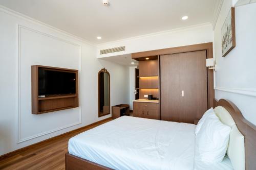 a bedroom with a bed and a flat screen tv at Ngoc Thu Palace in Soc Trang