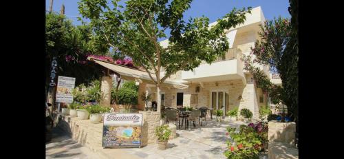 a building with a table and chairs in a garden at Fantastic Matala 1 in Matala