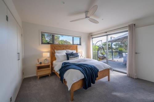 a bedroom with a large bed and a window at You Me And The Sea Blairgowrie in Blairgowrie