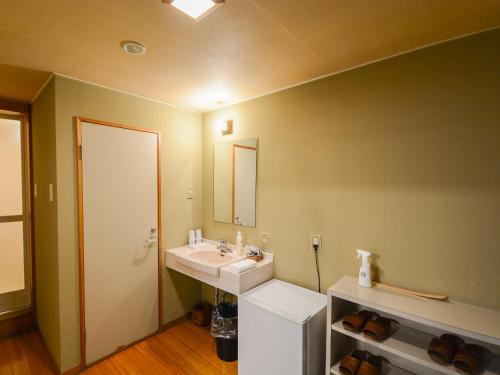 a bathroom with a sink and a mirror at Hoshikawakan in Yamanouchi