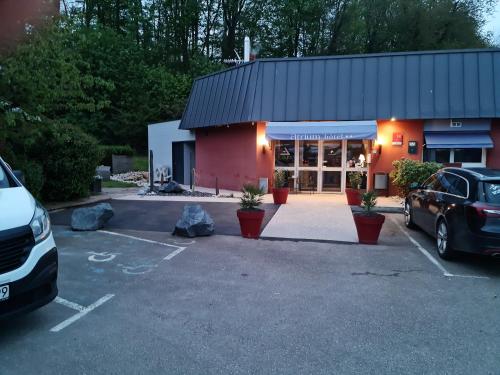 a car parked in a parking lot in front of a store at Logis Hôtel Atrium Epinal Golbey in Épinal