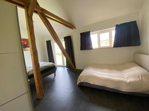 a bedroom with a bed and two windows in it at Spacious holiday home in the Teutoburg Forest in Schieder-Schwalenberg
