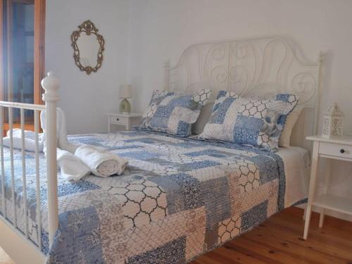 1 dormitorio con 1 cama con edredón y almohadas en Leonidas Comfortable holiday residence, en Pitsidia