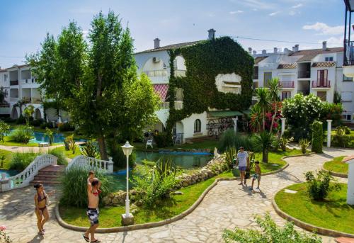 a group of people playing in a park with buildings at Apartments Kione Playa Romana Park in Alcossebre