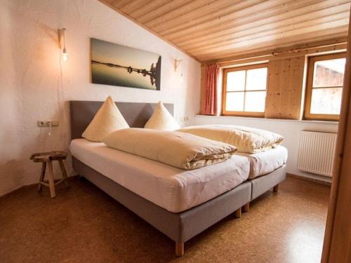 una cama con almohadas en una habitación en Nice holiday home near ski-lift, en Schwangau