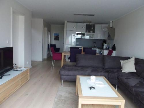 ein Wohnzimmer mit einem Sofa und einem Tisch in der Unterkunft Lütje Sandbank Modern retreat in Juist