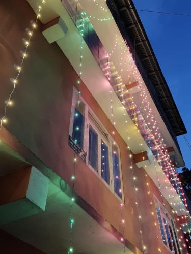 a house with christmas lights on the side of it at Travellers' Den in Darjeeling
