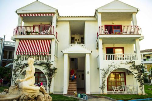 a large white building with a statue in front of it at Apartments Kione Playa Romana Park in Alcossebre