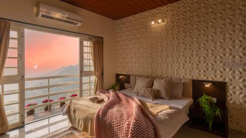 a bedroom with a bed and a large window at Fable Villa by Hill Staytion in Mahabaleshwar