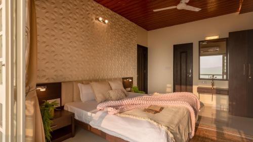 a bedroom with a bed with a blanket on it at Fable Villa by Hill Staytion in Mahabaleshwar