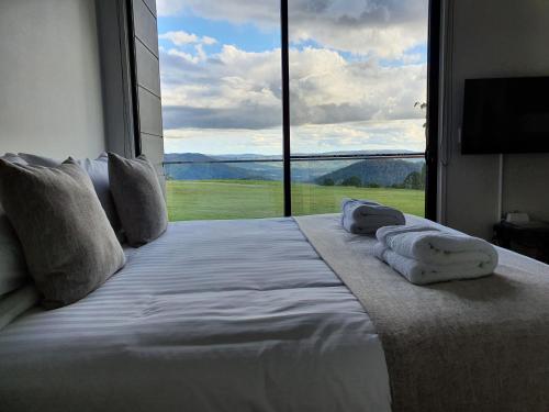 a bedroom with a large bed with a large window at Modern Couples Getaway in Witta