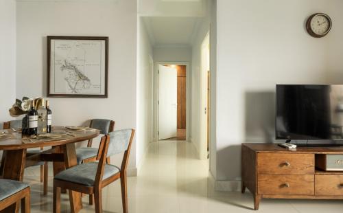 a living room with a dining table and a television at DingD0ng Home FelizEnVista 5-star facilities in Ho Chi Minh City