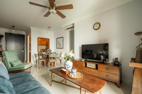 ein Wohnzimmer mit einem Sofa und einem TV in der Unterkunft DingD0ng Home FelizEnVista 5-star facilities in Ho-Chi-Minh-Stadt