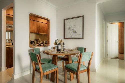 a dining room with a wooden table and green chairs at DingD0ng Home FelizEnVista 5-star facilities in Ho Chi Minh City