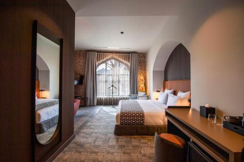 a hotel room with two beds and a large window at Qarvasla Hotel in Tbilisi City