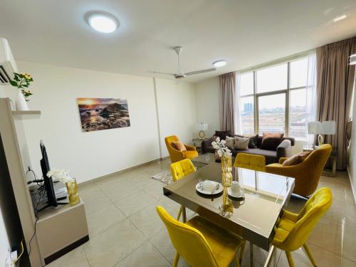 un soggiorno con tavolo e sedie gialle di WAAFI LA CORNICHE RESIDENCE a Gibuti