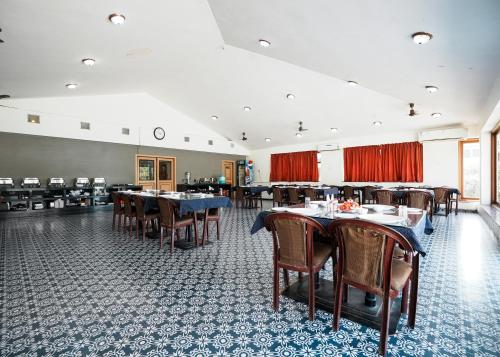 a dining room with tables and chairs and red curtains at Rupis Resort in Dabok